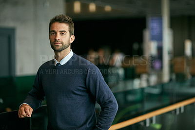 Buy stock photo Cropped portrait of a handsome young businessman standing alone in a library during the day