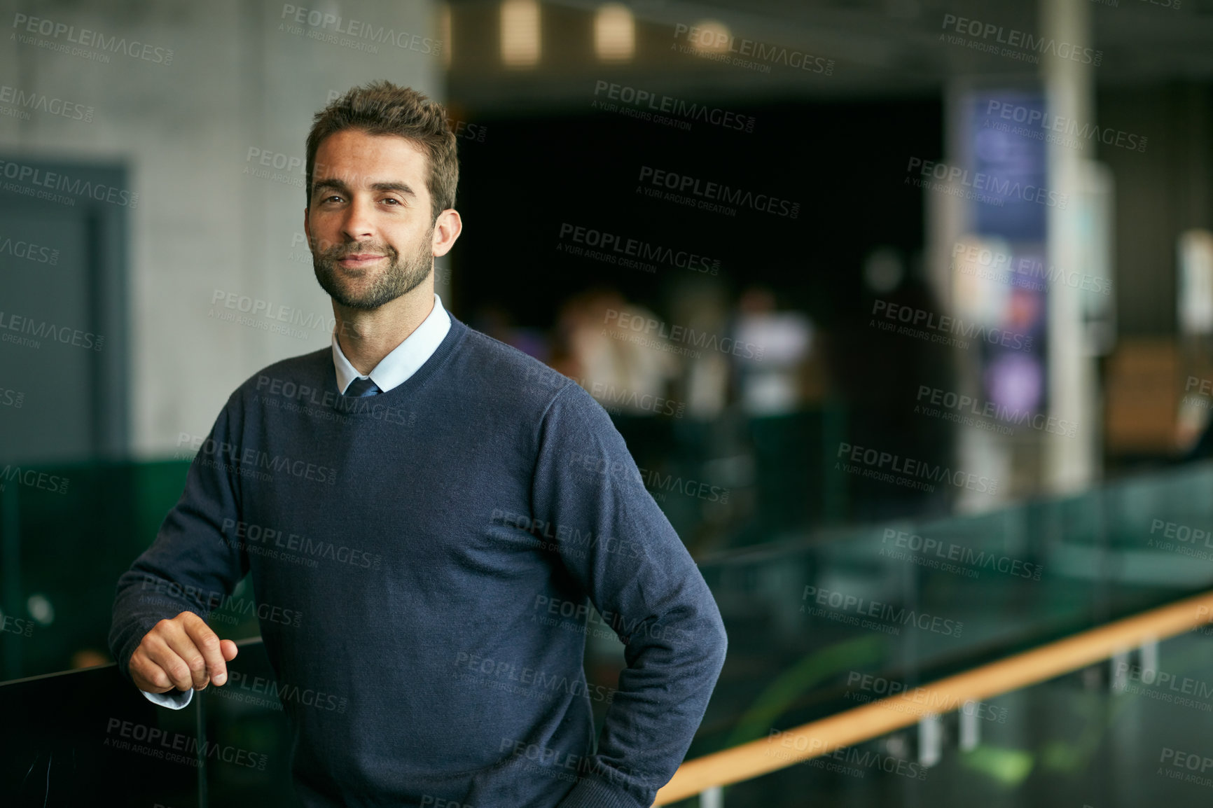 Buy stock photo Cropped portrait of a handsome young businessman standing alone in a library during the day