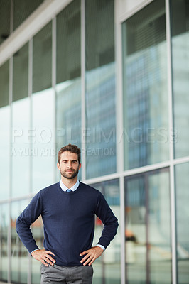 Buy stock photo Cropped portrait of a handsome young businessman standing alone outside with his hands on his hips