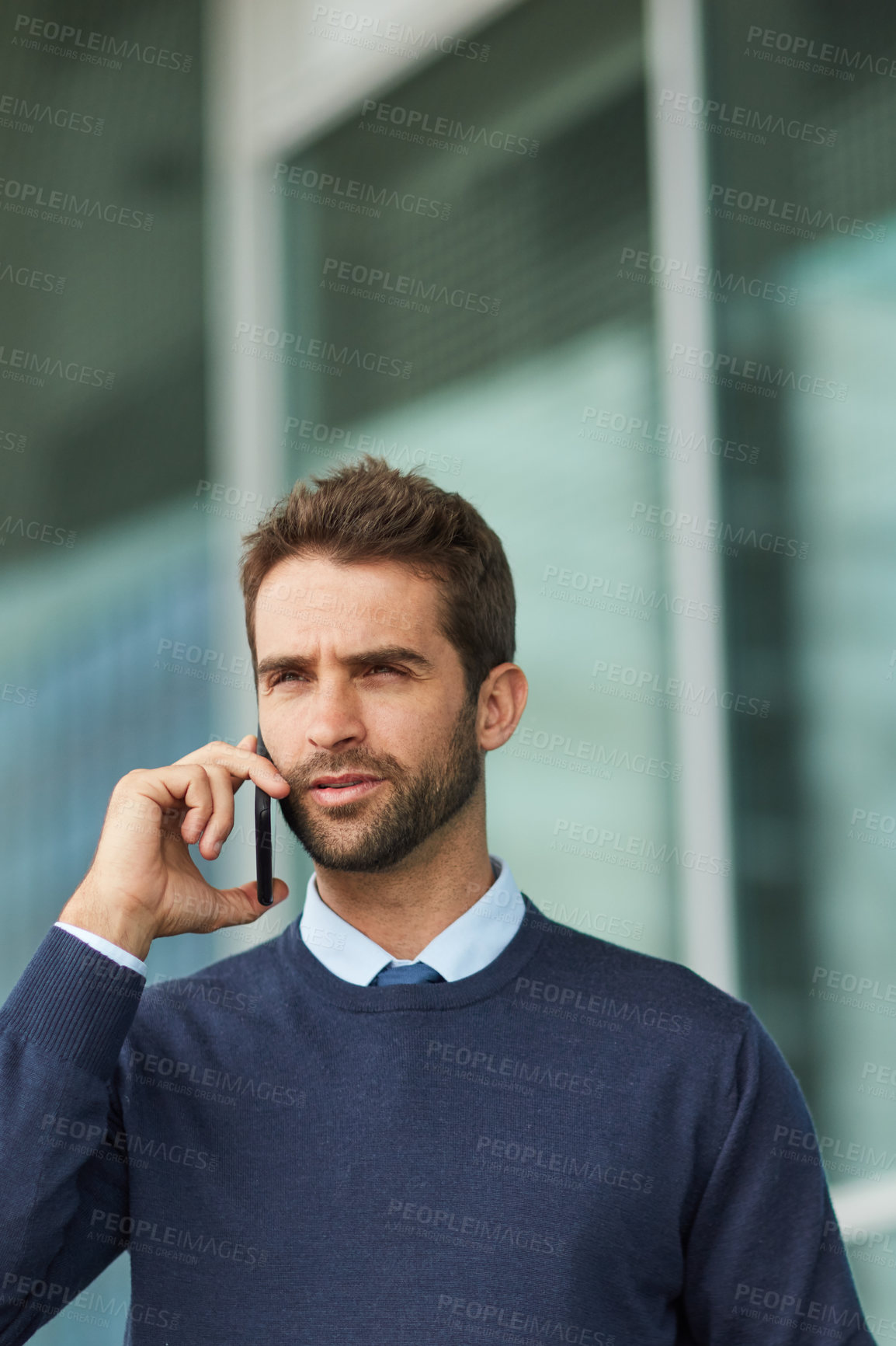 Buy stock photo Cropped shot of a handsome young businessman standing alone outside and using his cellphone during the day