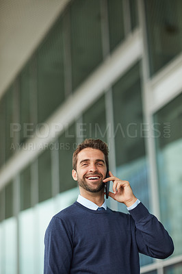 Buy stock photo Cropped shot of a handsome young businessman standing alone outside and using his cellphone during the day