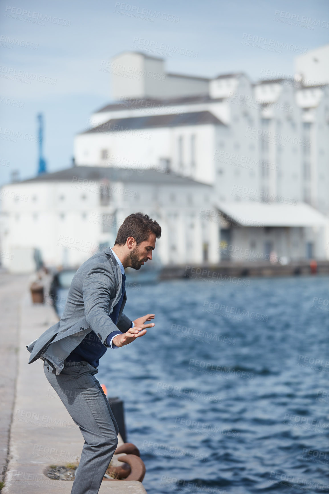 Buy stock photo Cropped shot of a handsome young businessman standing on the dock and wanting to jump into the water