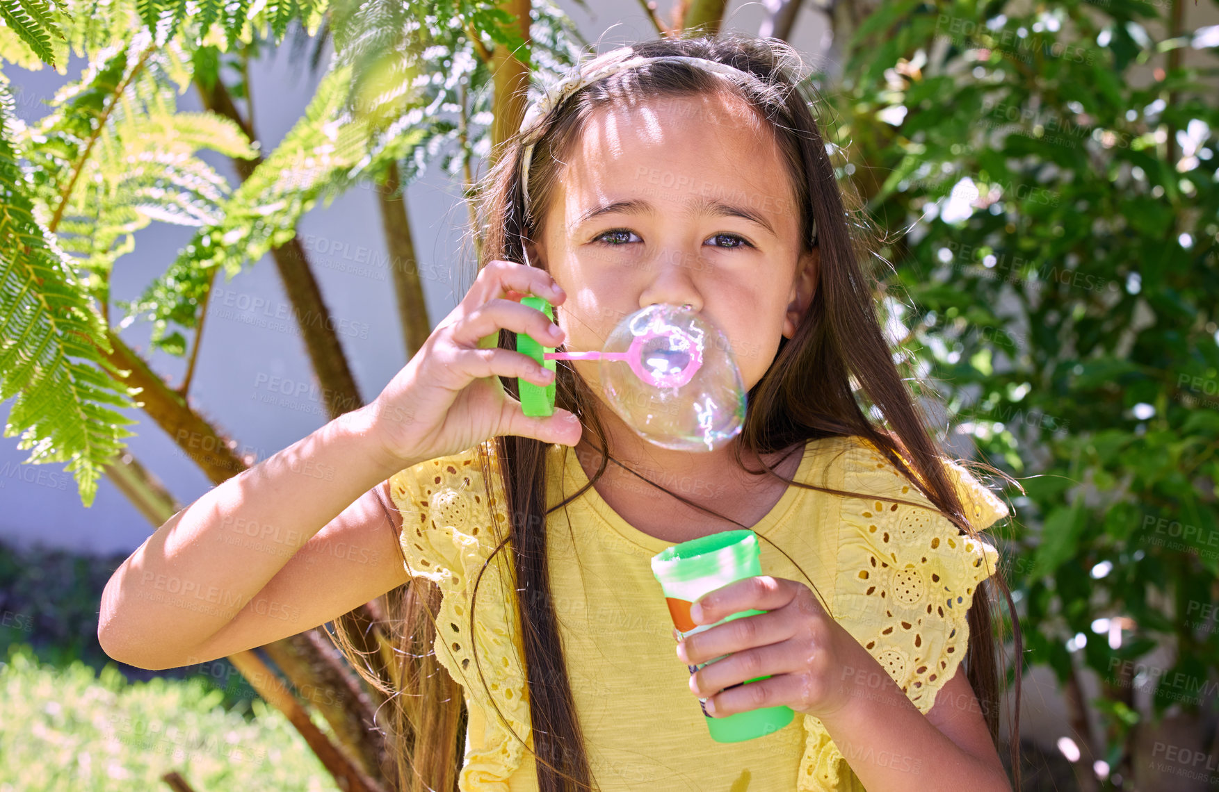 Buy stock photo Shot of an adorable little girl blowing bubbles outside