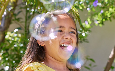 Buy stock photo Girl, child and happy with bubbles in garden for playing, excited or outdoor on vacation in summer. Kid, smile and soap for funny game in backyard, spring or sunshine by trees on holiday in Colombia