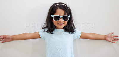 Buy stock photo Girl, child and smile with sunglasses by wall for summer, holiday and playful at family home. Kid, excited and happy with eyewear, games and fashion with trendy style, growth and development at house