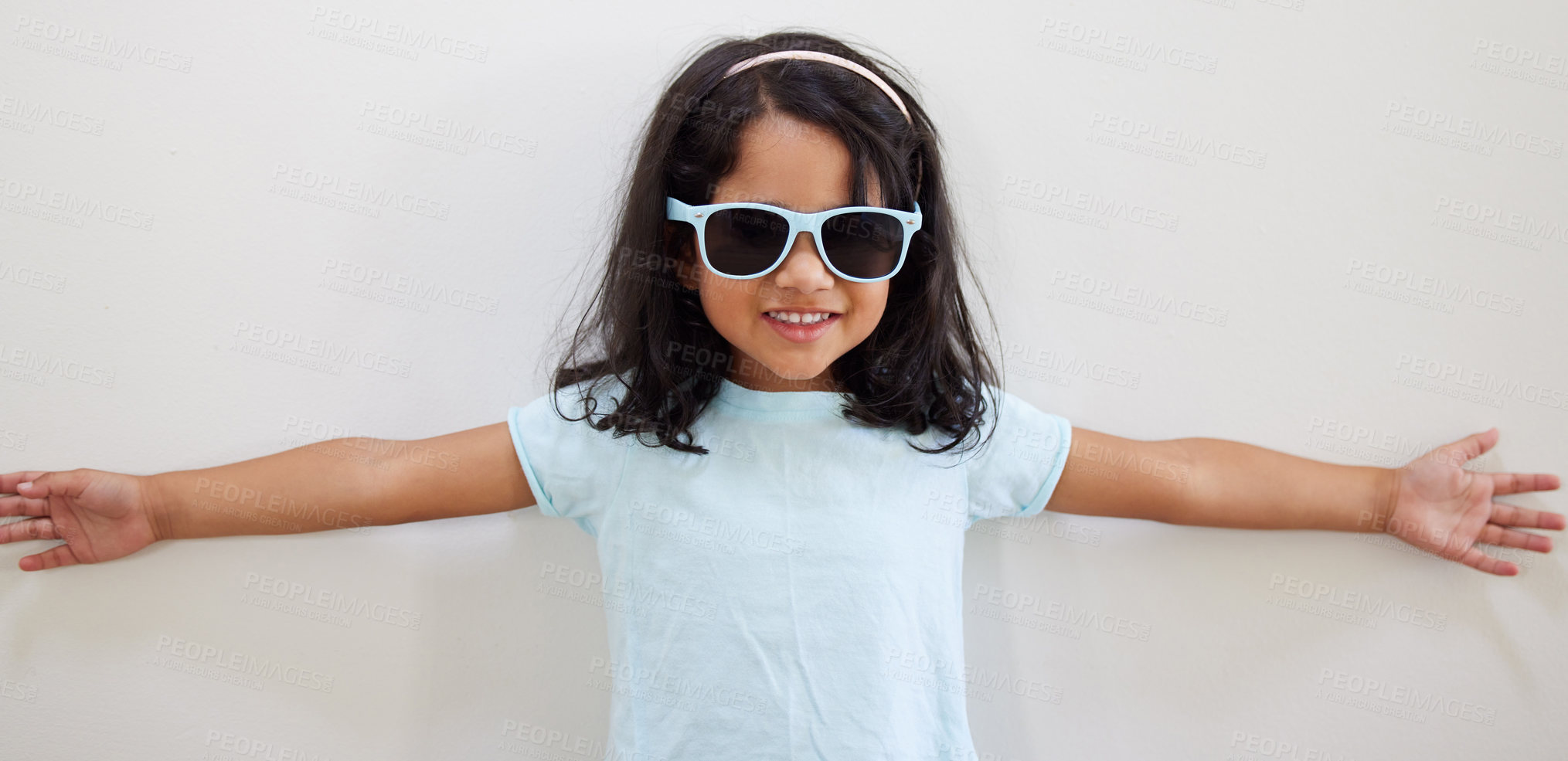 Buy stock photo Girl, child and smile with sunglasses by wall for summer, holiday and playful at family home. Kid, excited and happy with eyewear, games and fashion with trendy style, growth and development at house