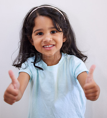 Buy stock photo Girl, child and thumbs up by wall in portrait for like, choice and agreement with smile in family home. Kid, happy and hands for sign language, symbol and trendy fashion with decision in Bogota