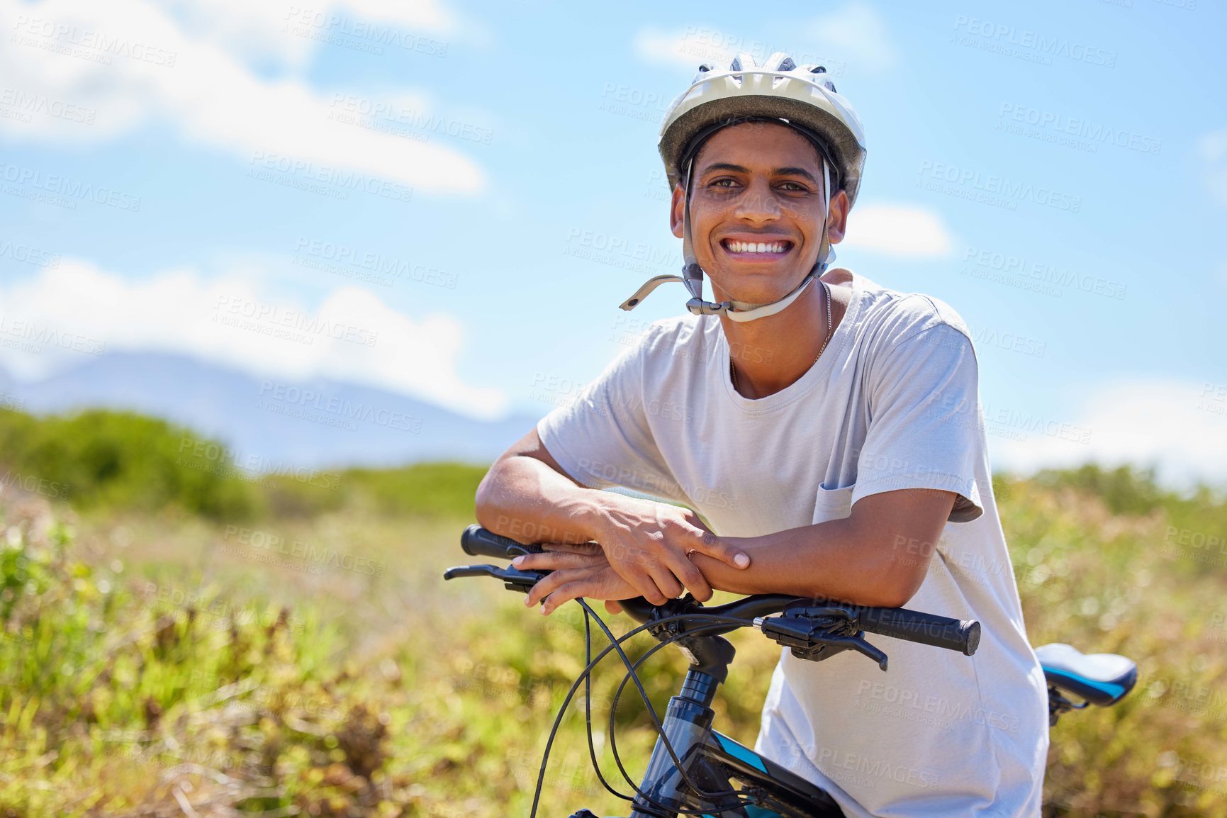 Buy stock photo Shot of a young man sitting on his bike in nature