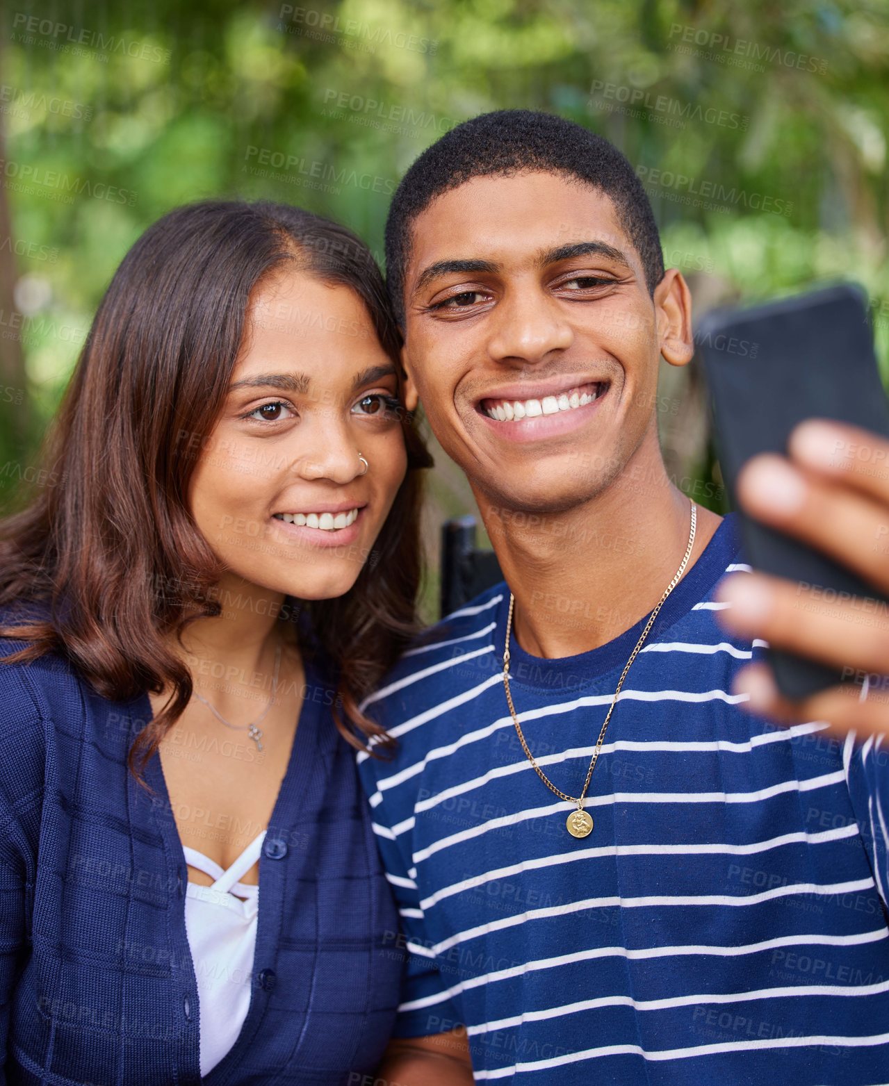 Buy stock photo Shot of a young couple taking a selfie outside