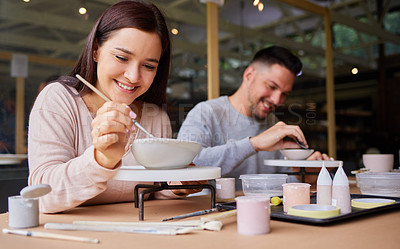 Buy stock photo Cropped shot of a young couple painting ceramics in an art studio