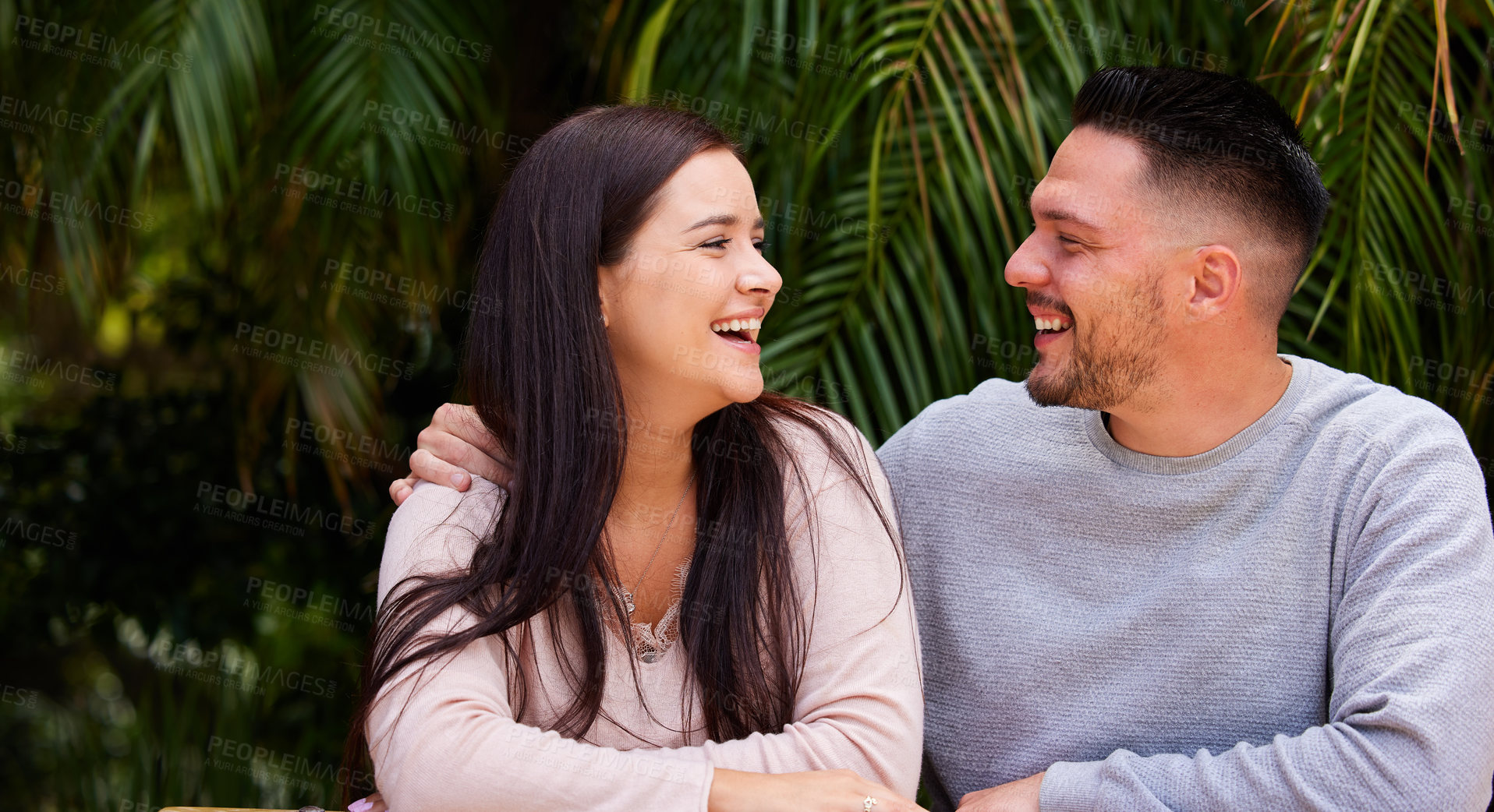 Buy stock photo Cropped shot of an affectionate laughing while sitting together outside