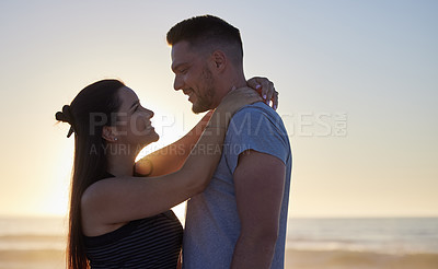 Buy stock photo Couple, hug and sunset for holiday on beach with smile, love and romance for anniversary or honeymoon. People, happy and embrace by ocean for summer sunrise, morning date and healthy relationship