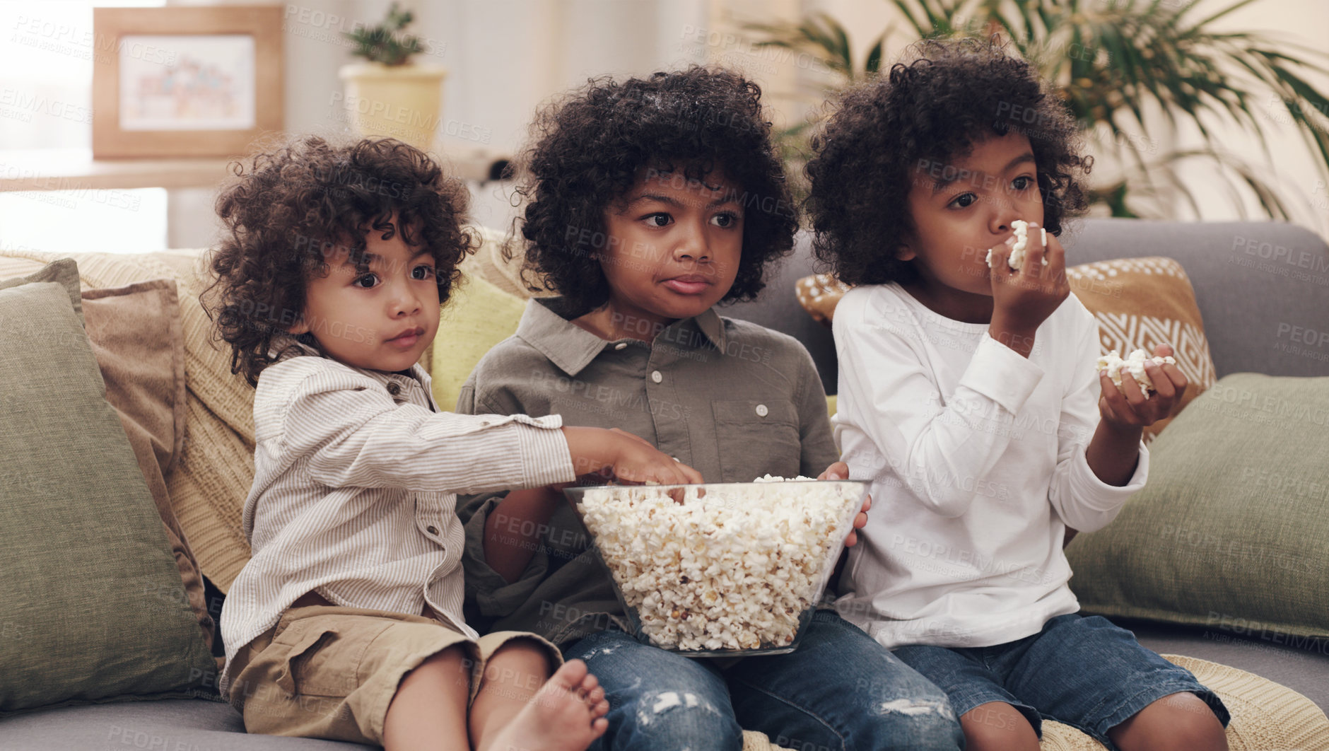 Buy stock photo Eating popcorn, couch and children in living room for bonding, cartoons and entertainment in school holidays. Brothers, together and snacking on sofa for childhood, tv shows and relaxing at home