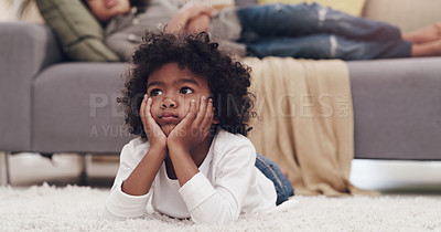 Buy stock photo Shot of an adorable little boy lying down on a carpet and watching tv at home