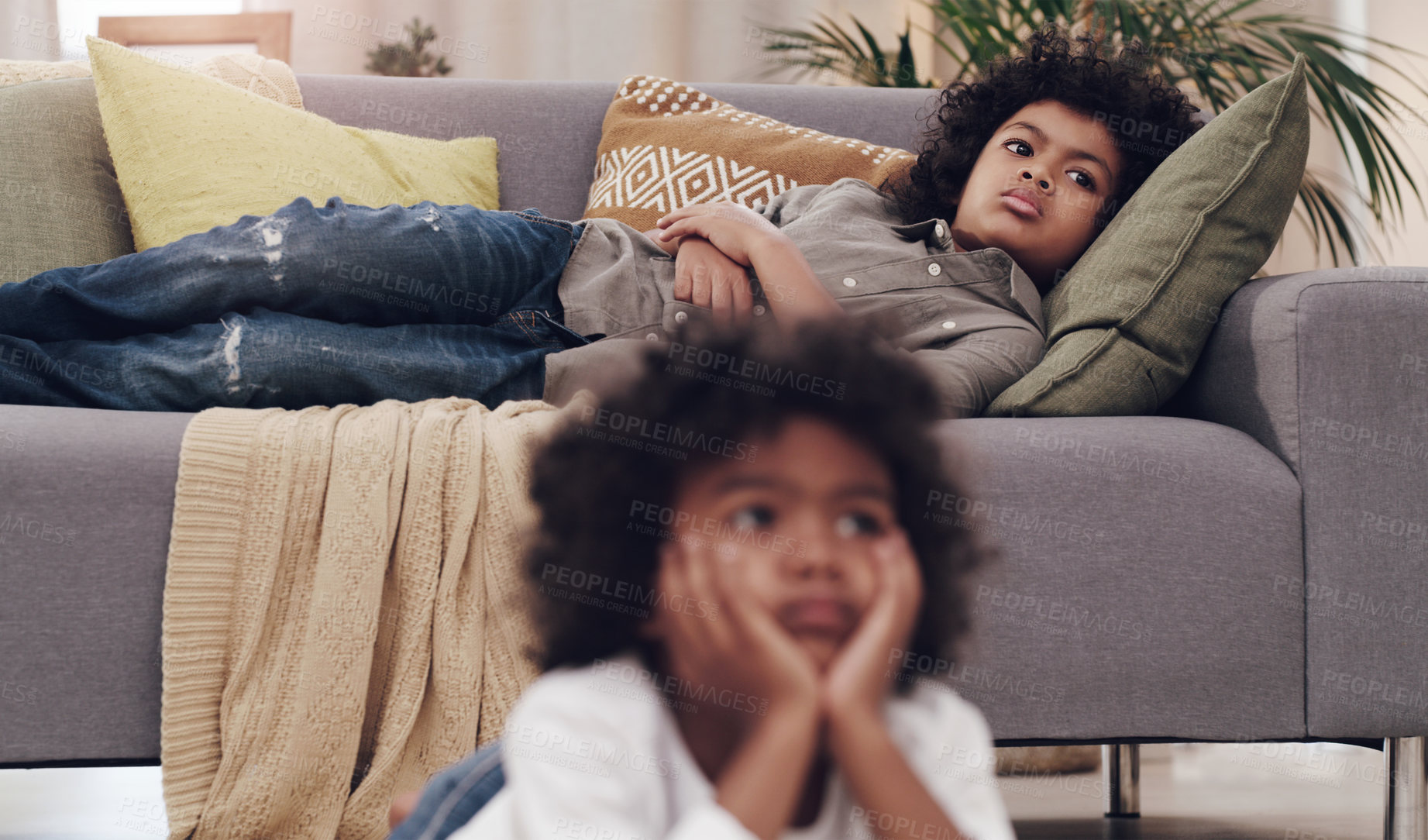 Buy stock photo Shot of two adorable little boys laying and watching tv together at home