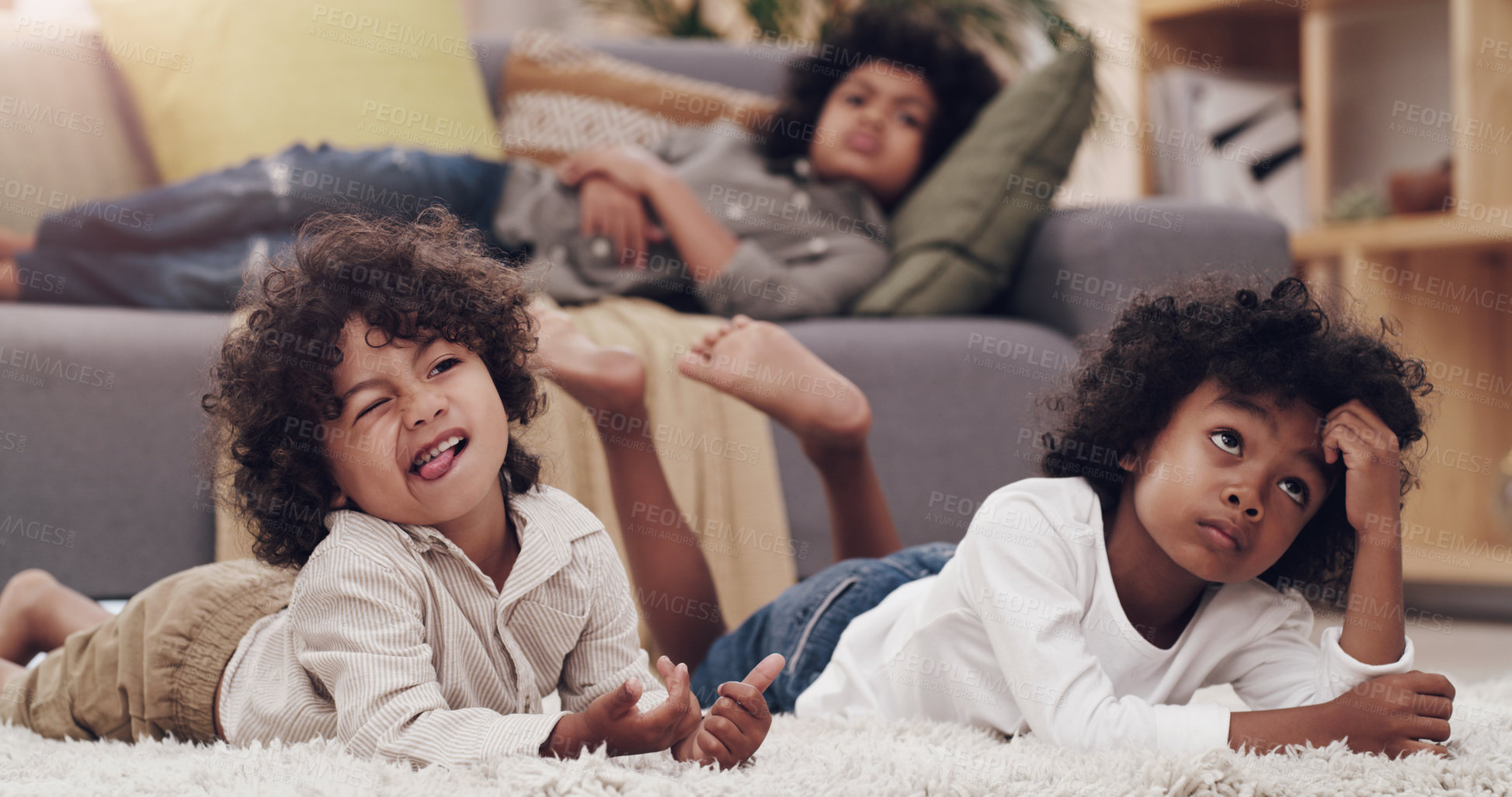 Buy stock photo Shot of three adorable little boys laying and watching tv together at home