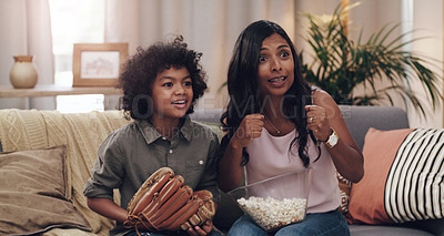 Buy stock photo Shot of an adorable little boy watching a baseball game with his mother on tv at home