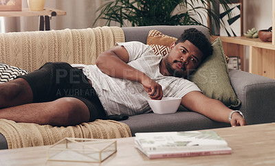 Buy stock photo Shot of a young man lying on his couch at home