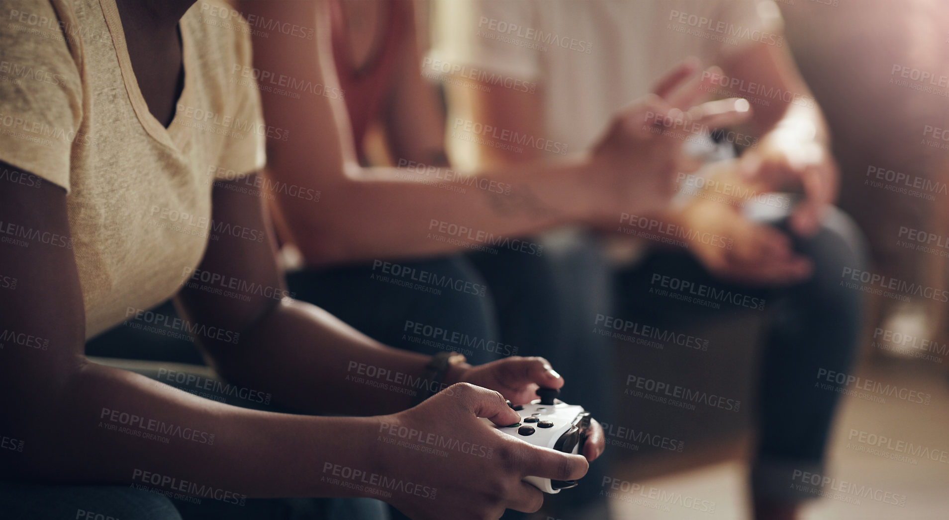 Buy stock photo Shot of a group of friends playing console games at home