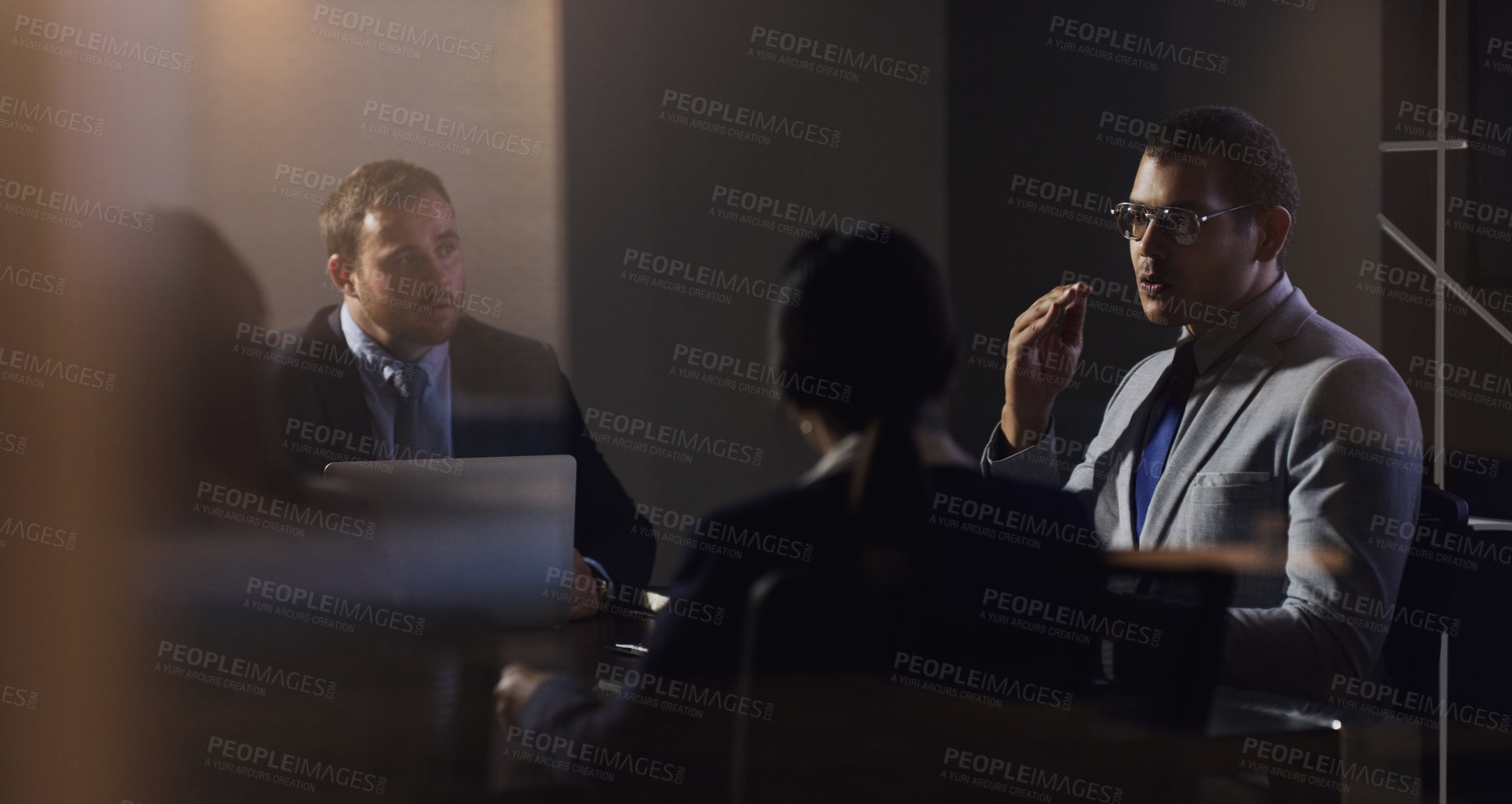 Buy stock photo Shot of a young businessman having a meeting with his colleagues in a boardroom