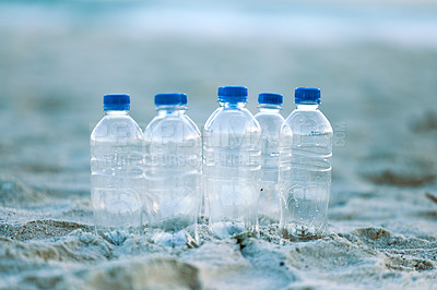 Buy stock photo Shot of bottles laying on the beach