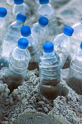 Buy stock photo Shot of bottles laying on the beach