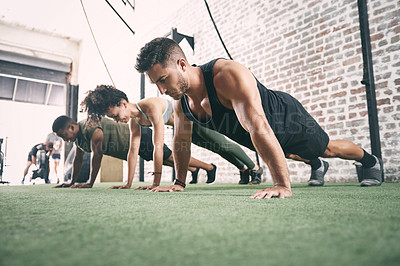 Buy stock photo Shot of a fitness group doing push-ups at the gym