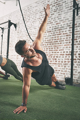 Buy stock photo Shot of a man doing the side plank at the gym