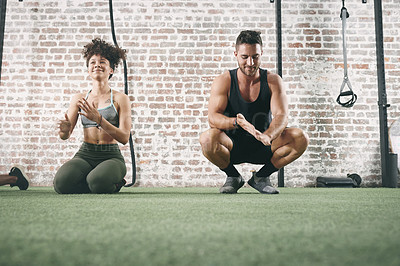 Buy stock photo Shot of two sporty young people dusting off their hands while working out at the gym