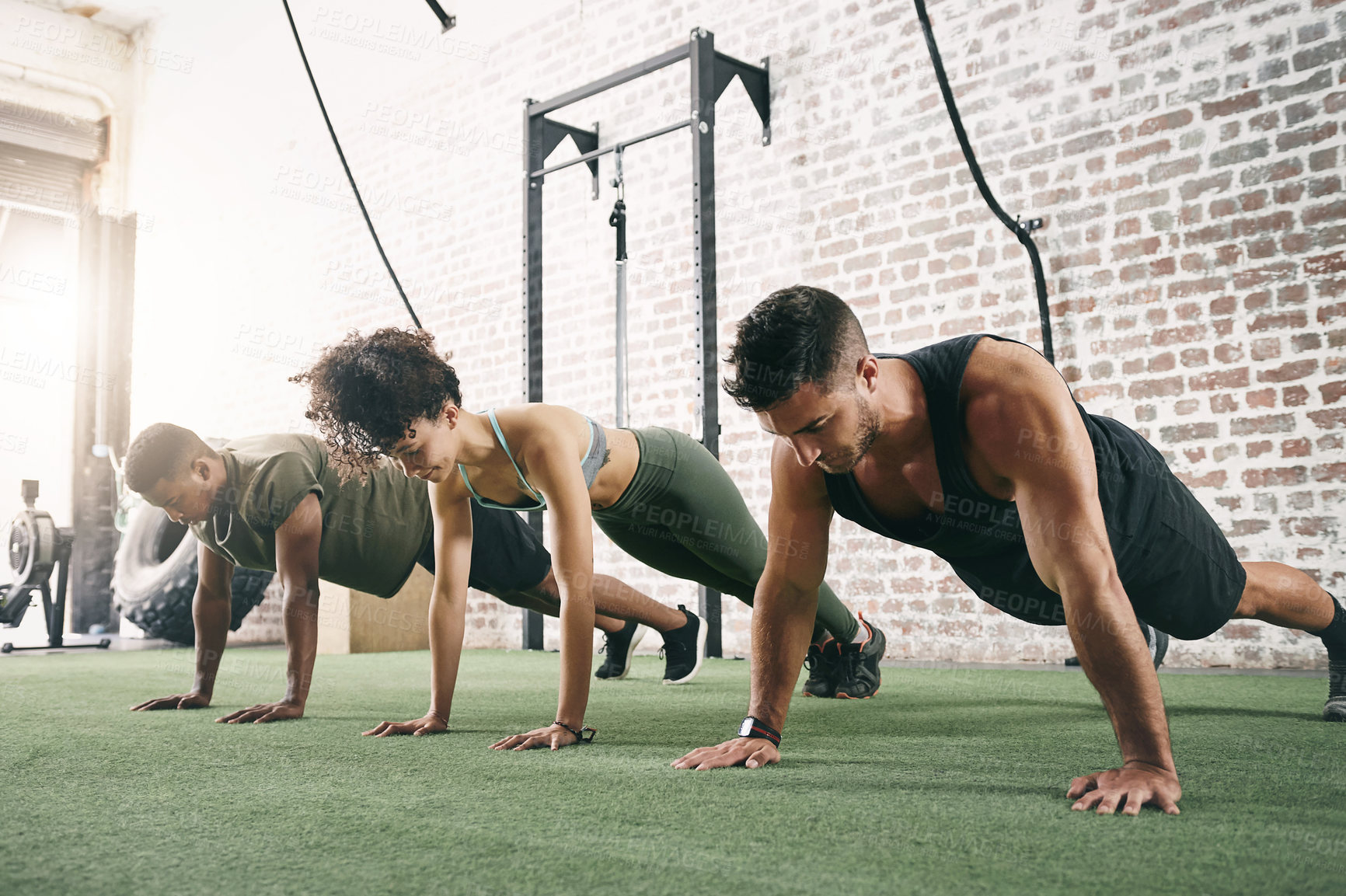 Buy stock photo Shot of a fitness group doing push-ups at the gym