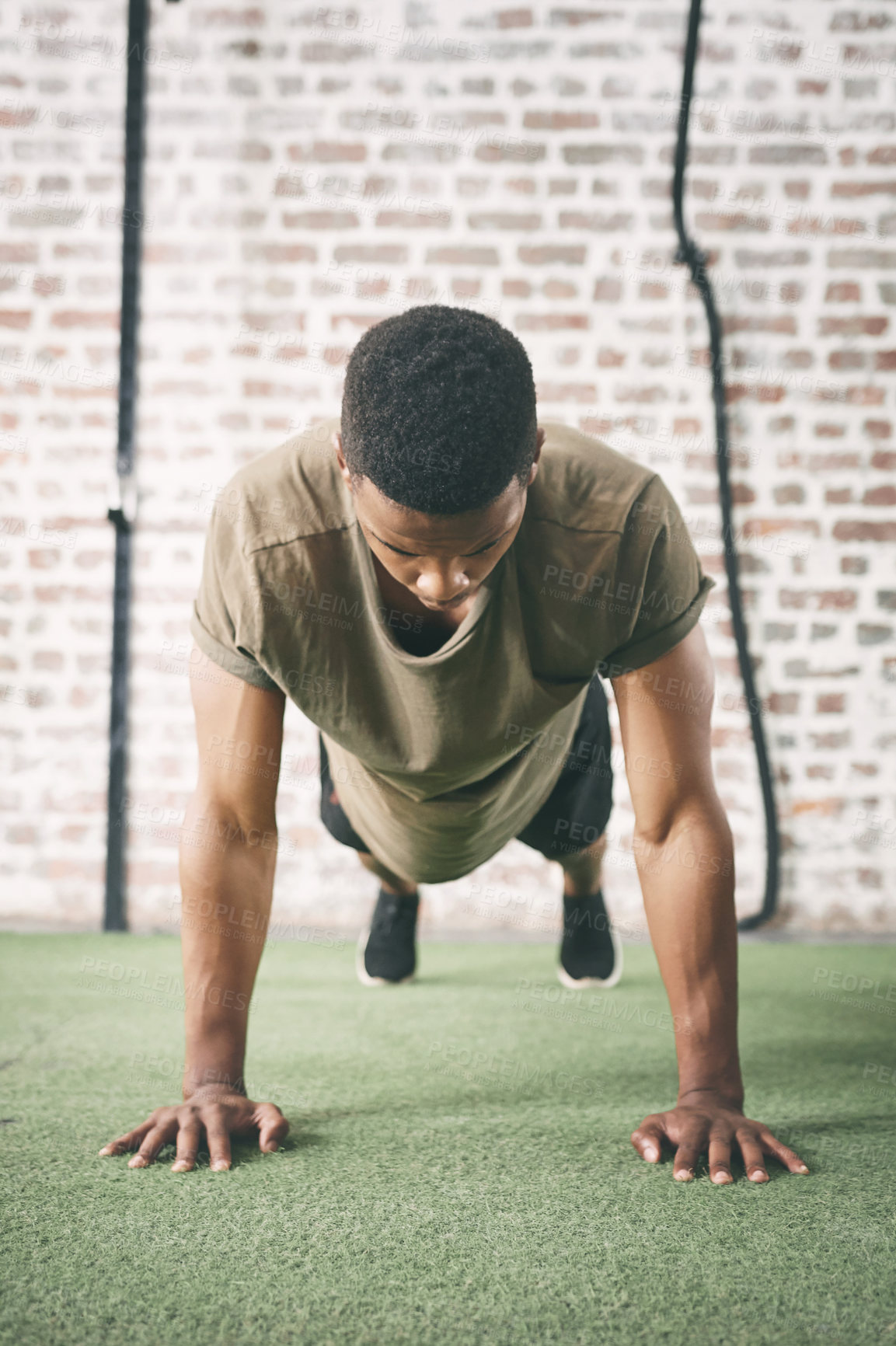 Buy stock photo Shot of a sporty young man doing pushups at the gym