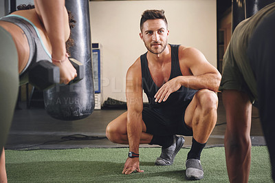 Buy stock photo Shot of two people working out with a fitness instructor at the gym