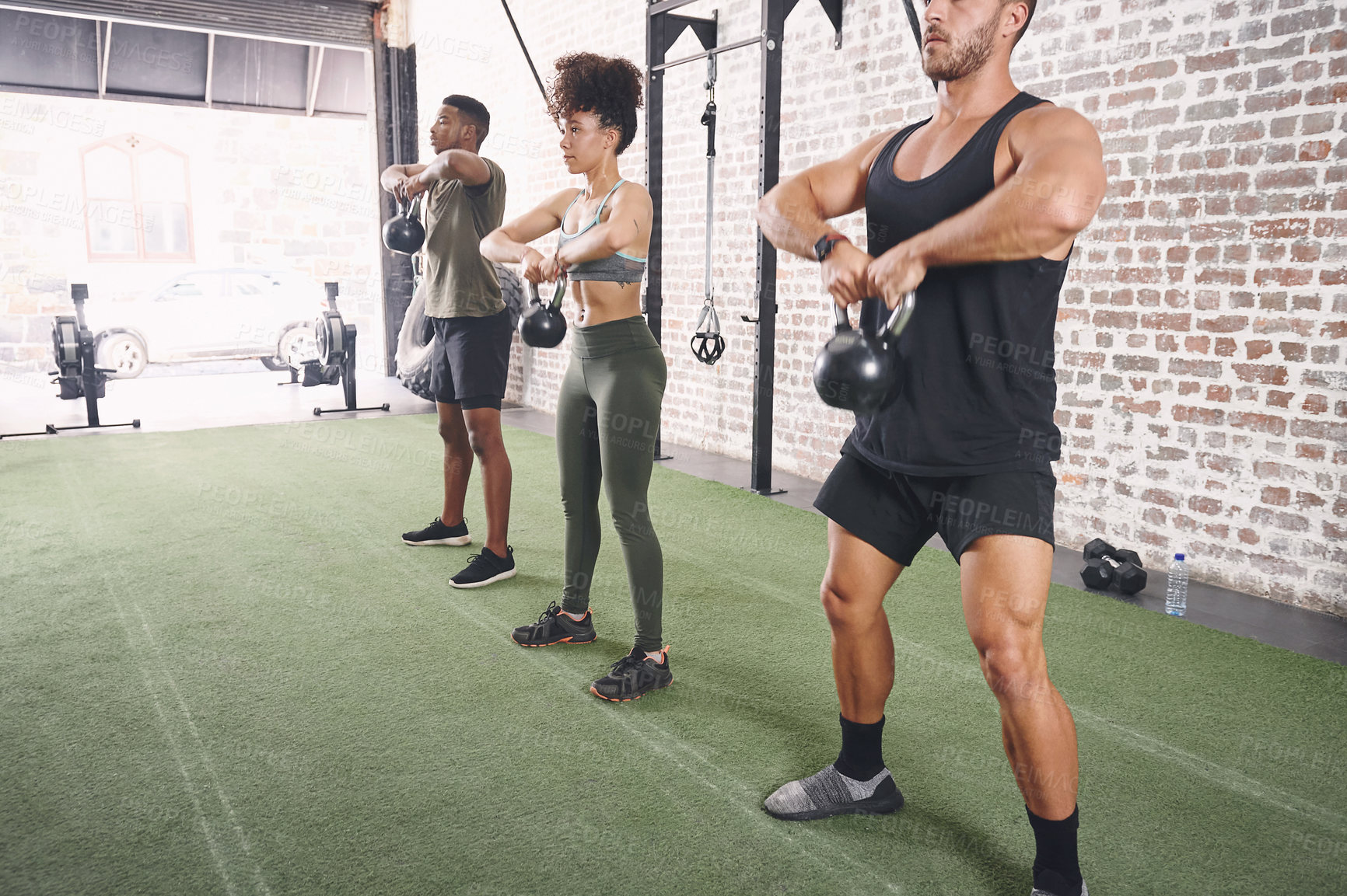 Buy stock photo Shot of a fitness group using kettlebells while working out at the office