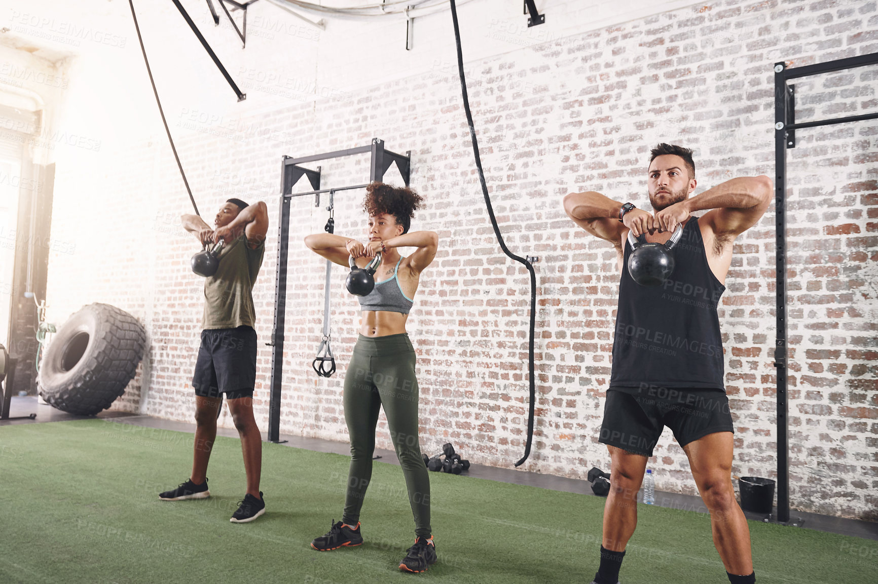 Buy stock photo Shot of a fitness group using kettlebells while working out at the gym