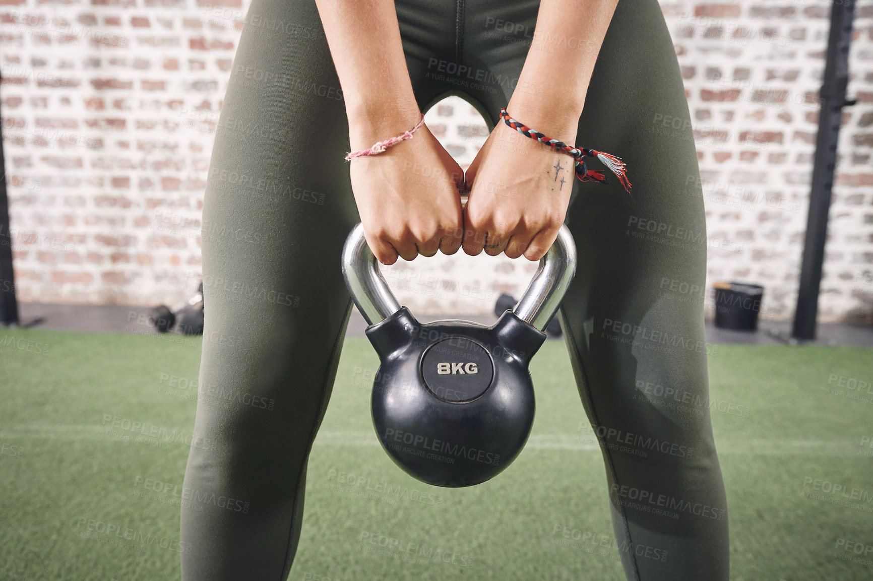 Buy stock photo Shot of a sporty young woman working out with a kettlebell at the gym