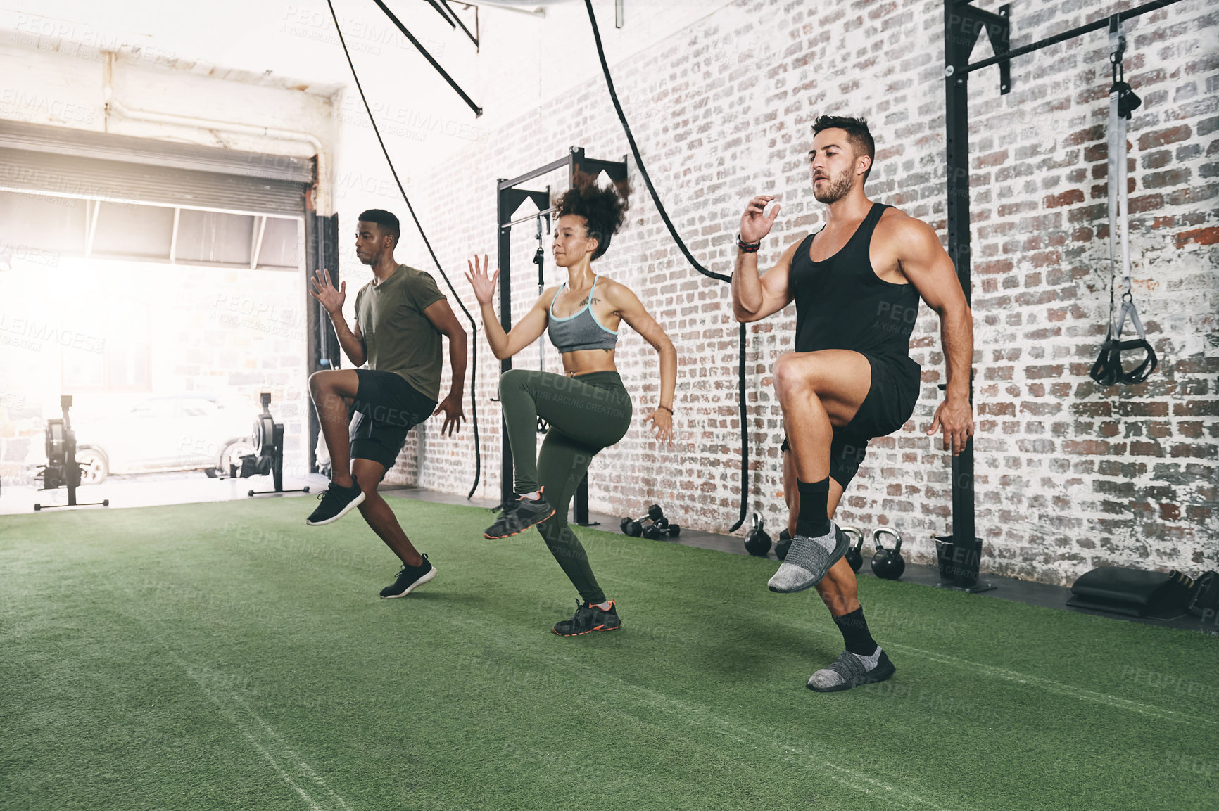 Buy stock photo Shot of a fitness group doing high knees while working out at the gym