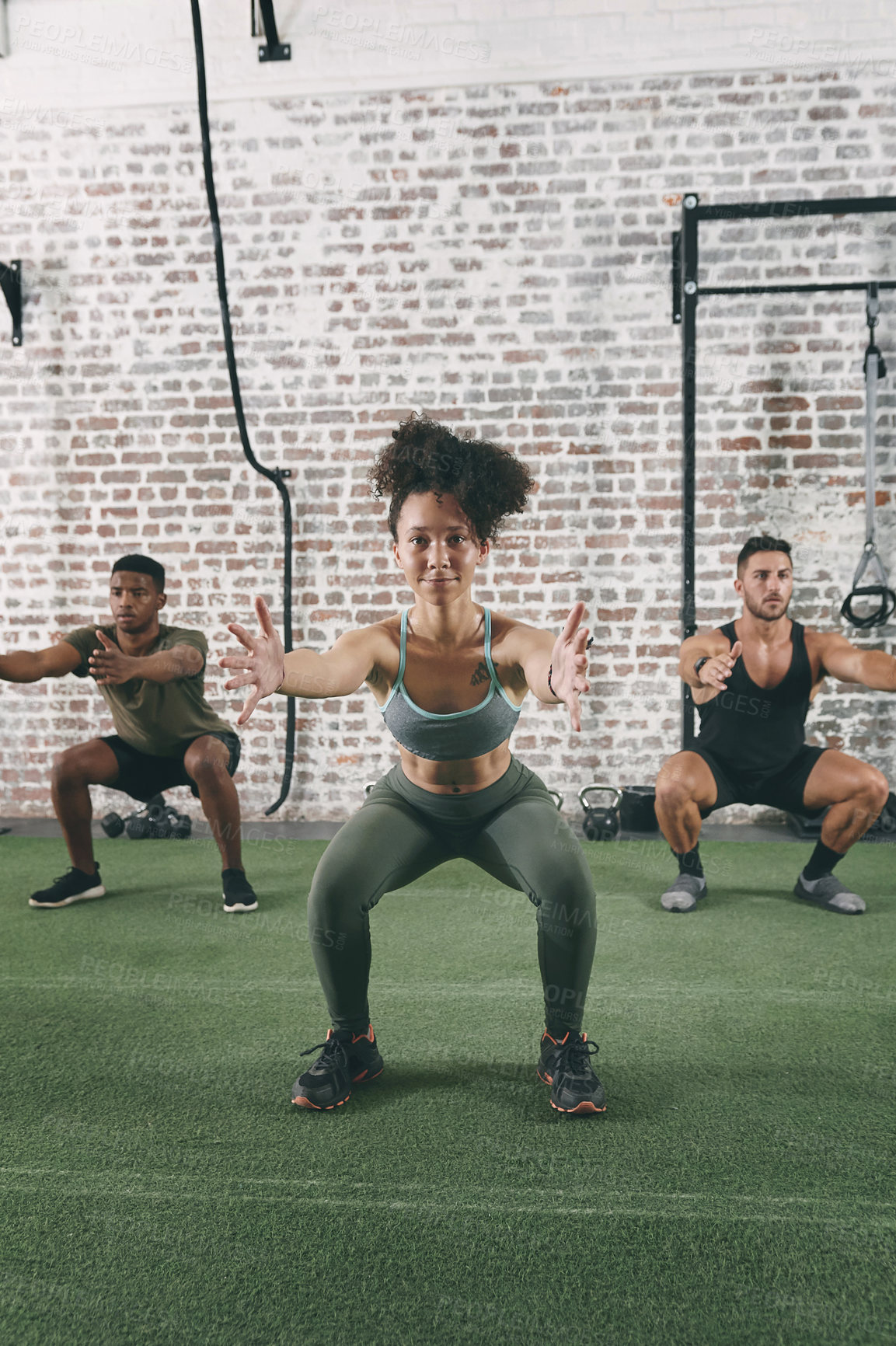 Buy stock photo Shot of a fitness group doing squats while working out at the gym