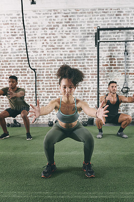 Buy stock photo Shot of a fitness group doing squats while working out at the gym