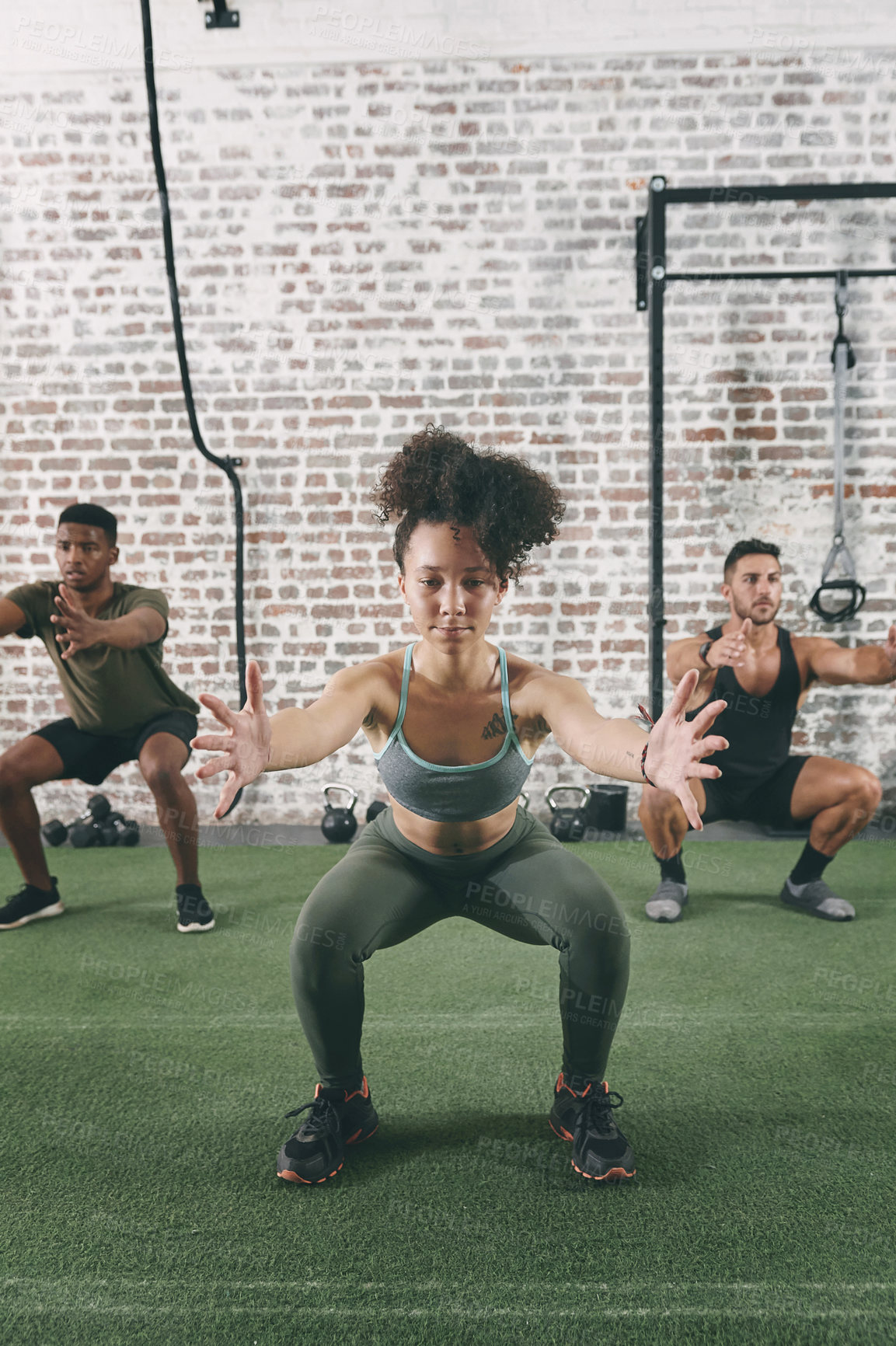 Buy stock photo Shot of a fitness group doing squats while working out at the gym