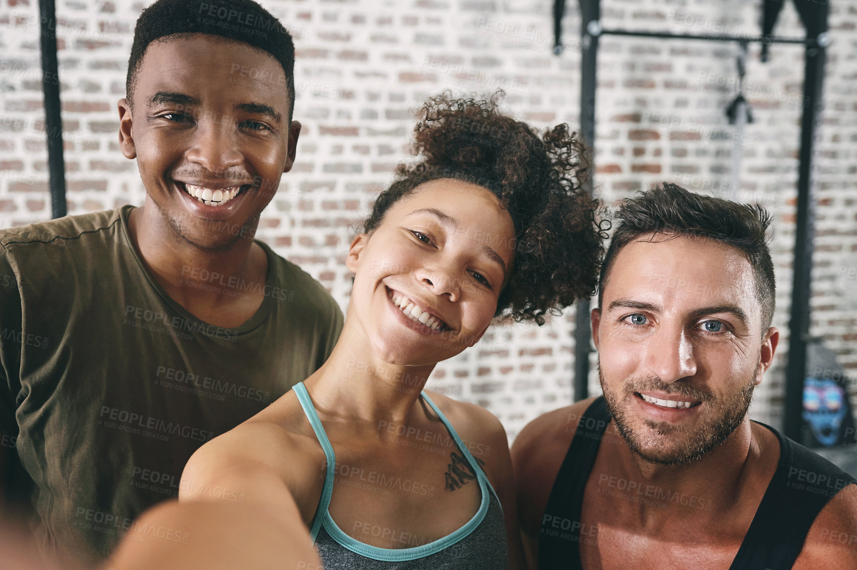 Buy stock photo Cropped shot of three sporty young people taking a selfie at the gym