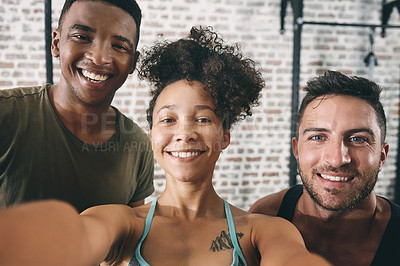 Buy stock photo Cropped shot of three sporty young people taking a selfie at the gym