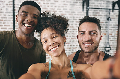 Buy stock photo Cropped shot of three sporty young people taking a selfie at the gym