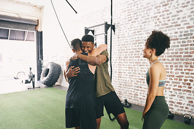 Buy stock photo Shot of three sporty young people looking cheerful at the gym