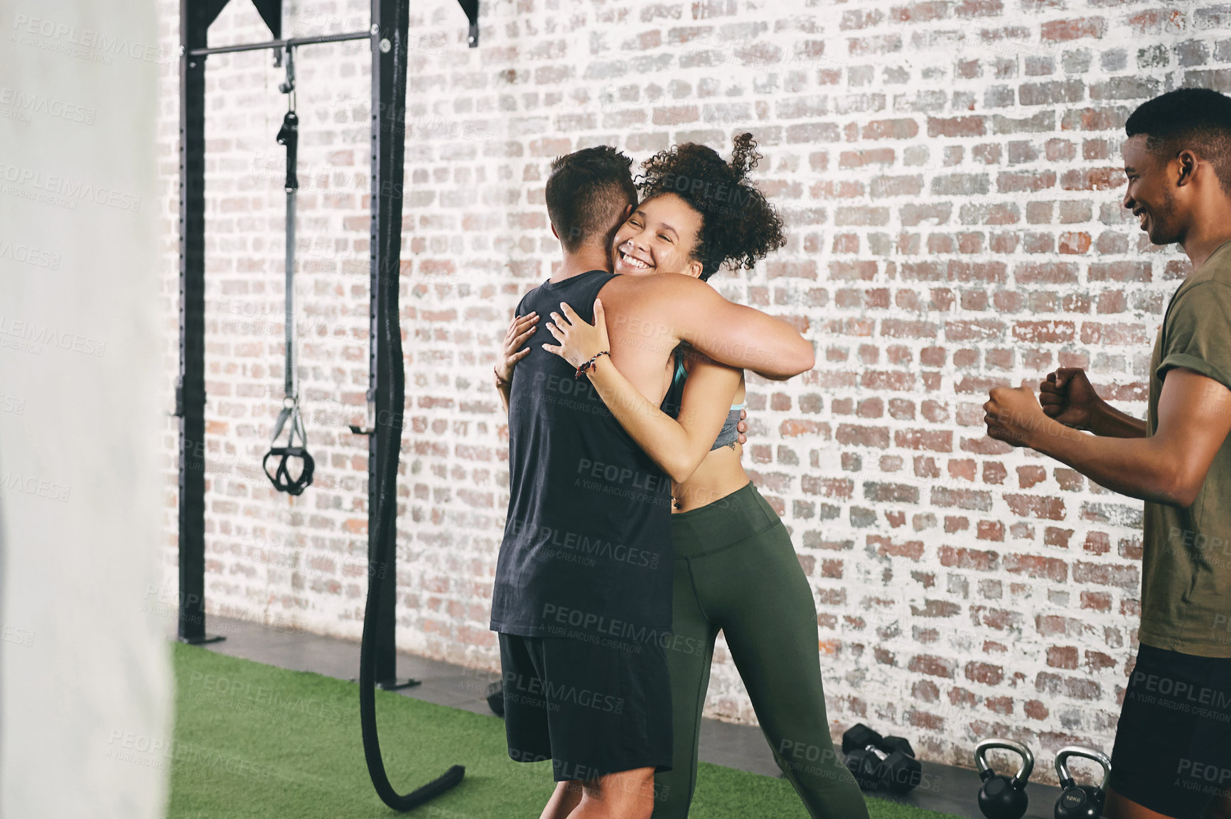 Buy stock photo Shot of three sporty young people looking cheerful at the gym