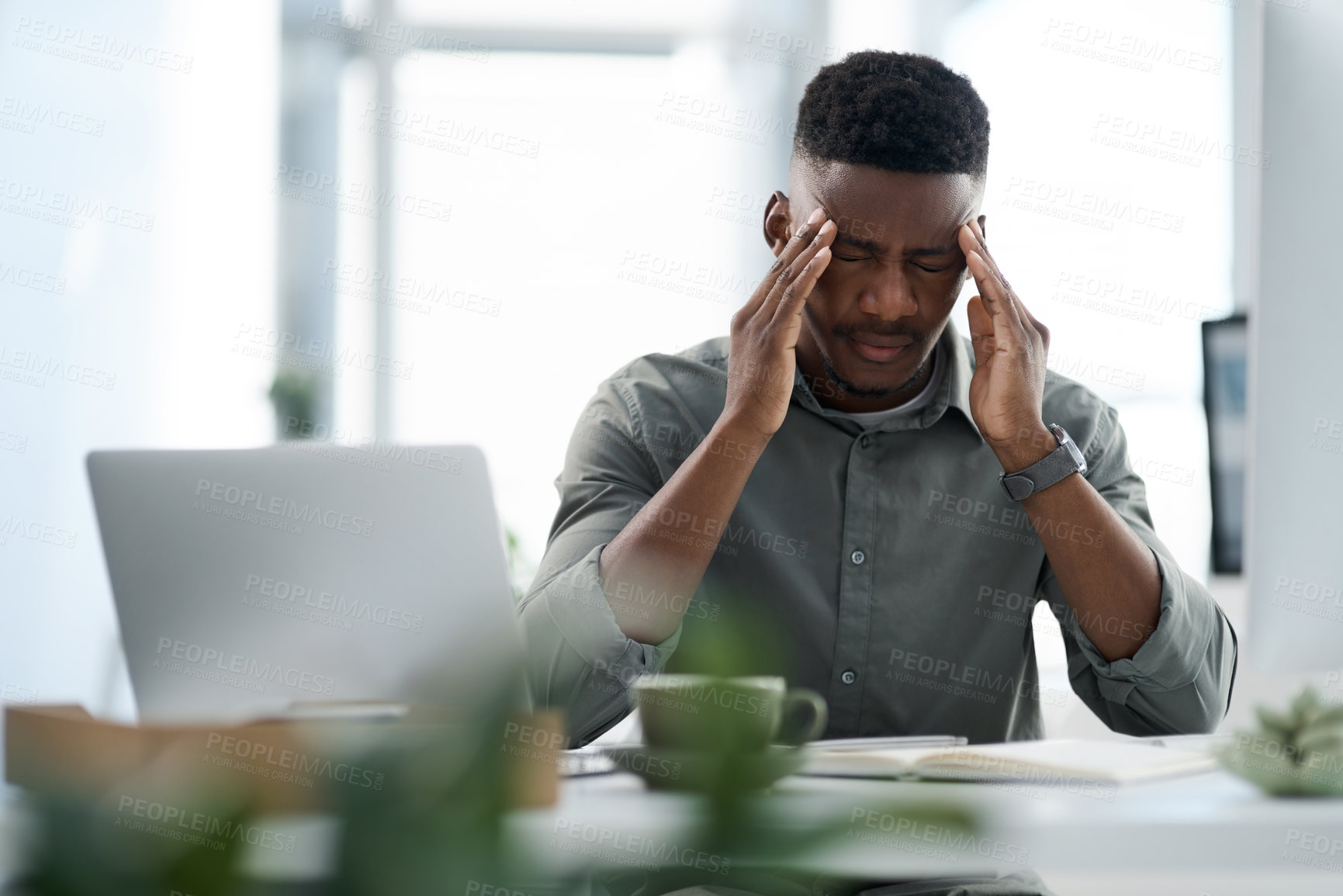 Buy stock photo Shot of a young businessman working on a computer in an office