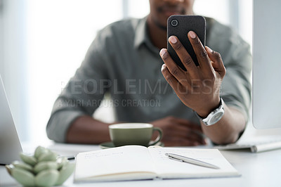 Buy stock photo Cropped shot of a young man using his phone at work