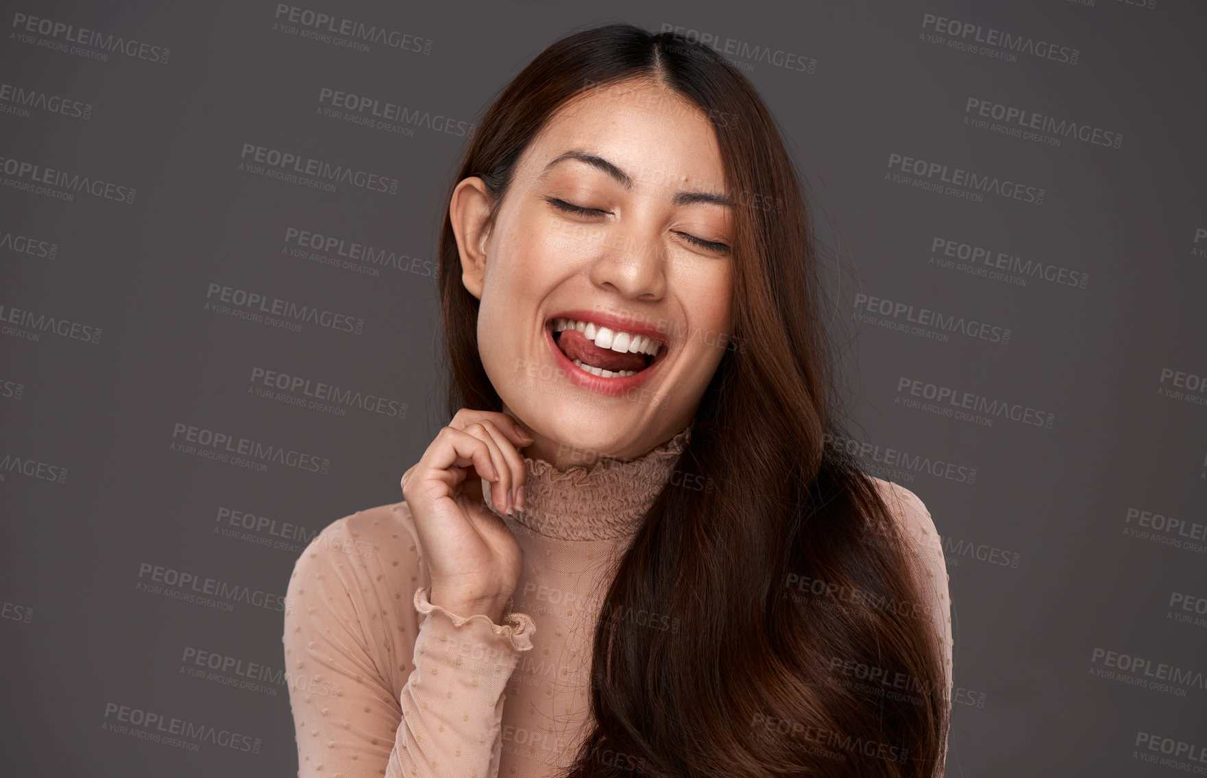 Buy stock photo Cropped shot of an attractive young woman making a face in studio against a grey background