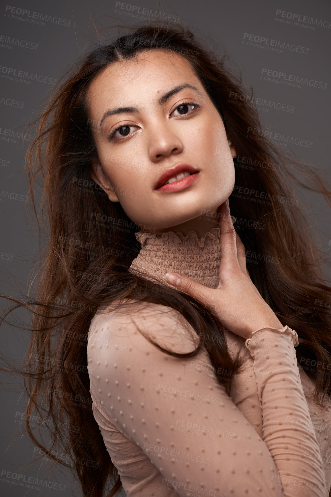 Buy stock photo Cropped portrait of an attractive young woman posing in studio against a grey background