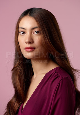 Buy stock photo Cropped portrait of an attractive young woman posing in studio against a pink background