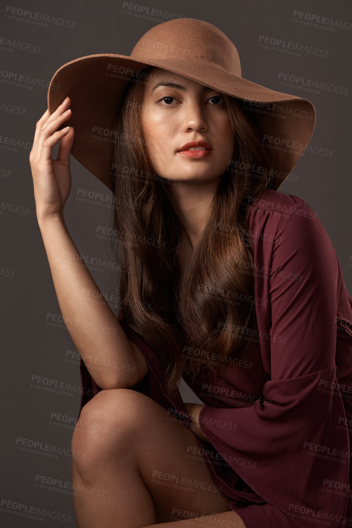 Buy stock photo Cropped portrait of an attractive young woman posing in studio against a grey background